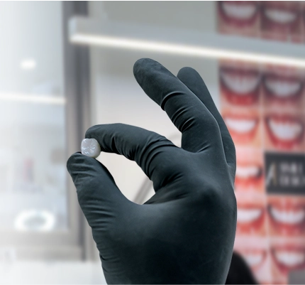 dental specialist holding a dental crown close-up