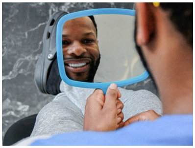 A patient looking in the mirror and smiling